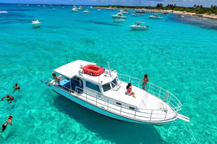 a blue and white boat sitting next to a body of water