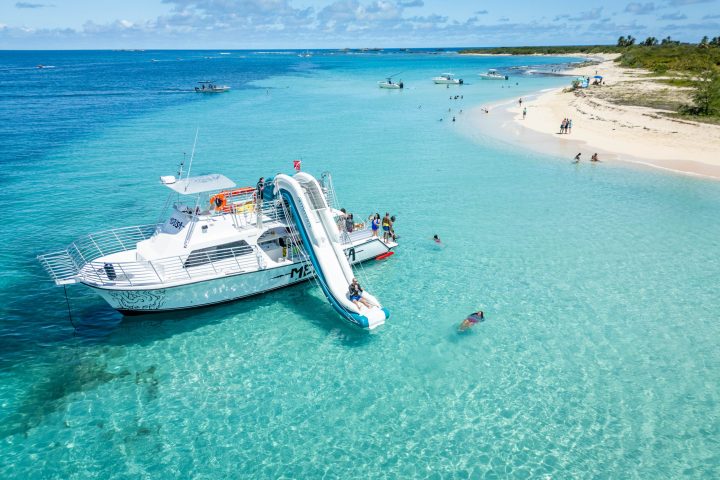 a blue and white boat sitting next to a body of water