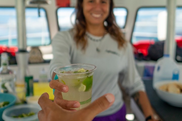 a person holding a tray of food on a table