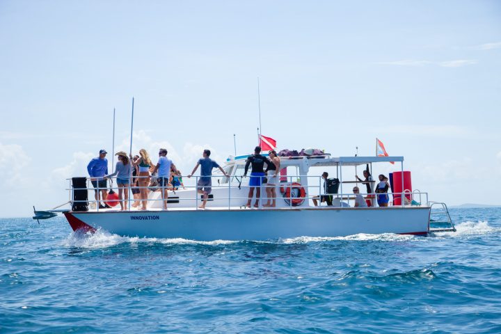 a group of people riding on the back of a boat in the water