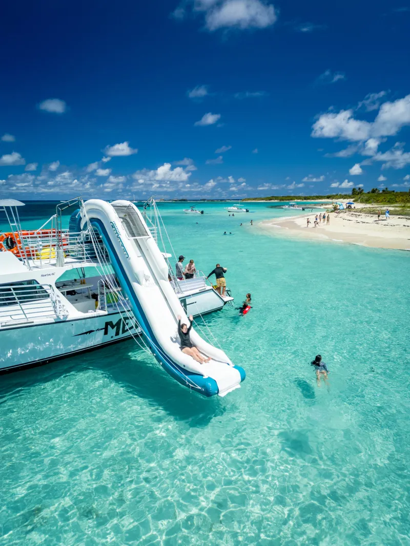 a blue and white boat sitting next to a body of water